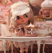 Miniature carousel gift collection displayed with cloth doll for scale reference, vintage collectible carousel for doll display