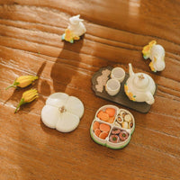 Oriental Osmanthus pastry tea set vintage miniature collectible displayed in Mid-Autumn Festival setting, festive mooncake-themed decor with warm ambient lighting